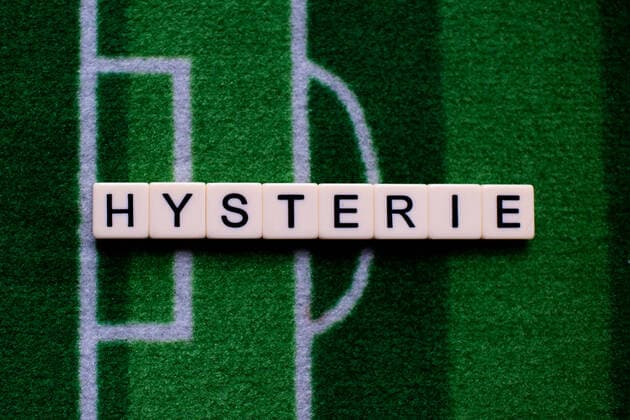 The coronavirus Covid 19 causes event cancellations of, for example, football matches of Bundesliga professionals for an indefinite period of time and many effects, in the picture The word hysteria on a football carpet Germany