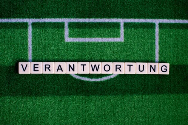 The corona virus Covid 19 causes events such as football matches of Bundesliga professionals to be cancelled indefinitely and has many consequences, in the picture The word responsibility on a football carpet Germany