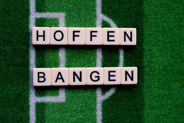 The corona virus Covid 19 causes events such as football matches of Bundesliga professionals to be cancelled indefinitely and has many consequences, in the picture The word hope and fear on a football carpet Germany