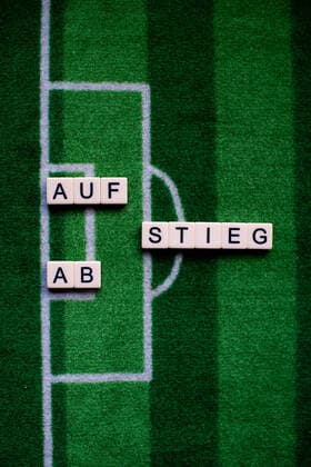 The corona virus Covid 19 causes event cancellations of, for example, football matches of Bundesliga professionals for an indefinite period of time and many effects, in the picture The word rise and fall on a football carpet Germany