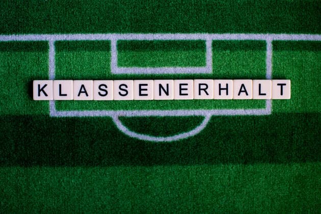 The coronavirus Covid 19 causes event cancellations of, for example, football matches of Bundesliga professionals for an indefinite period of time and many effects, in the picture The word class preservation on a football carpet Germany