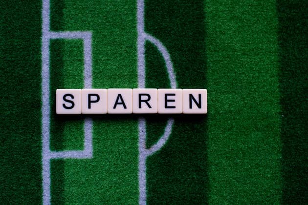 The corona virus Covid 19 causes event cancellations of, for example, football matches of Bundesliga professionals for an indefinite period of time and many effects, in the picture The word saving on a football carpet Germany