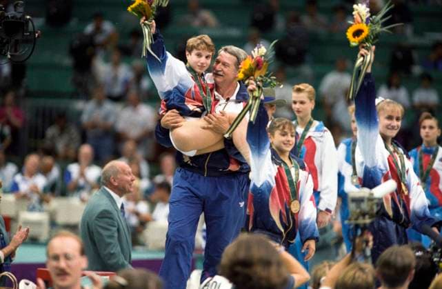 Olympics Gymnastics 1996 Bela Karolyi USA Coach carries Kerri Strug (USA) with her injured ankle to the presentation of the gold medal for the team all around at the 1996 Olympic Summer Games. Atlanta GA USA Copyright: xPaulxJ..xSutton DUOMO PCNx GY0101 106004