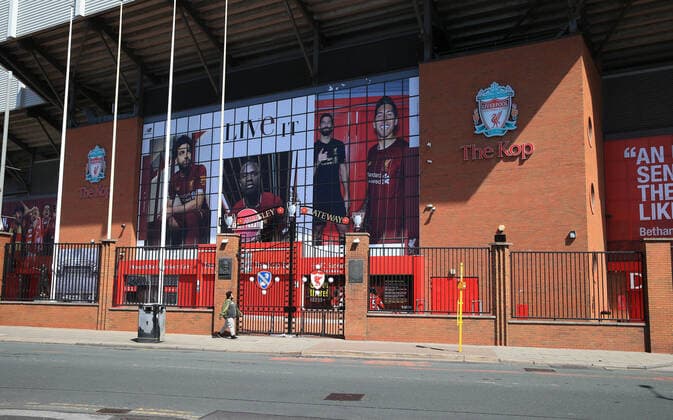 May 4th 2020, Liverpool, United Kingdom; Anfield stadium during the suspension of the Premier League due to the Covid-19 virus pandemic; a passer by looks through the locked and deserted Paisley Gateway entrance to the Kop  ActionPlus12218566 DavidxBlunsden