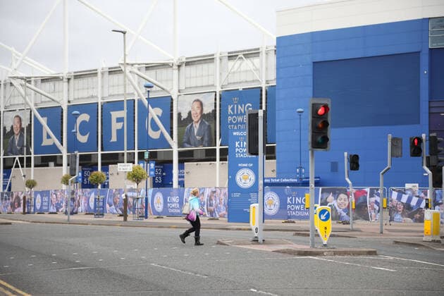 A lady walks close to the King Power Stadium are quiet whilst Leicester City play a football match against Crystal Palace behind closed doors on day one hundred and three of lockdown and Leicester has become the first local area to be placed back into lockdown, whilst most of the country has had a further relaxation of Coronavirus restrictions including being able to go to pubs, barbers and hairdressers. 