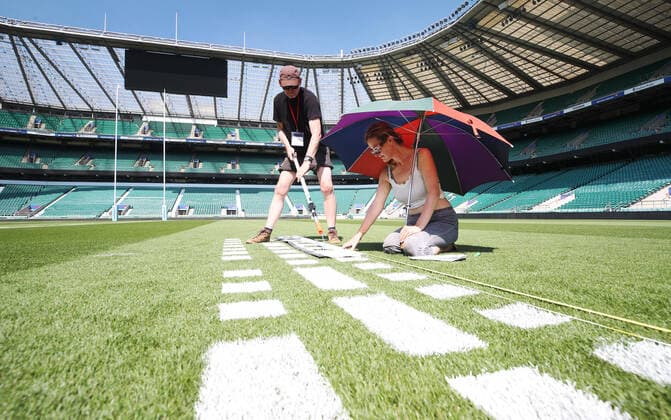The pitch at Twickenham Stadium has been transformed into a stunning portrait featuring three of Premiership Rugby?s star players today (12th August 2020). The giant rugby art, the largest outdoor painting ever created in the UK, was unveiled to celebrate the restart of Gallagher Premiership Rugby on Friday 14 th August when Harlequins take on Sale Sharks at 7:45pm, just 200 metres away. The artwork features Harlequins player, Joe Marler; Saracens? Maro Itoje, as well as Sale Sharks? Rugby World Cup winner Faf de Klerk. It took team of eight artists more than 24 hours to complete the pitch portrait and more than 100 hours of planning before any paint touched the grass. A bespoke computer program was written to generate the precise measurements that were needed to create the artwork to the exact scale of the stadium. The image, which occupies most of the 7,000 square metre pitch, was created using a grid comprised of 13,420 elements. Each painted line in the portrait is just 6 inches wide. Nearly 1280 litres of biodegradable pitch marker paint were used for the elaborate creation. An estimated 150,000 passengers will enjoy the spectacle from the sky this week on flights in and out of London?s Heathrow airport. Faf de Klerk was one of the featured Premiership Rugby stars in the portrait. The Sale Sharks star said, I didn t realise it was going to be on the field, I thought it was going to be a photo up somewhere or on the big screen. It s looking really cool. There are a lot of great players in the Premiership, and it is amazing. I feel really privileged and quite humble . Speaking about the impact of lockdown on the Saracens star Maro Itoje said The last few months have been really tough on fans and players but we?re back and we?re ready for the start of the season on Friday 14th August. The past five months has shown us how important the sport is and what it brings to people lives. British artist John Lundberg, who oversaw the po Copyright: xScottxGarfitt PinPep CoverxImagesx 0103040133st EDITORIAL USE ONLY. RESTRICTED TO NEWSPAPERS BASED IN THE UK