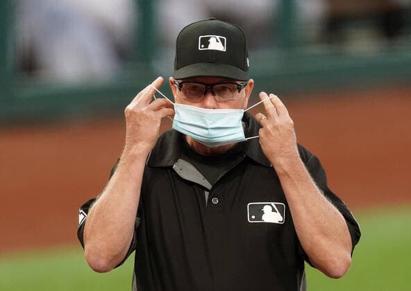 Third base umpire Jerry Meals puts on his face mask for the lineup card exchange at home plate before a game between the Kansas City Royals and the St. Louis Cardinals at Busch Stadium in St. Louis on Tuesday, August 25, 2020.  SLP2020082512 BILLxGREENBLATT