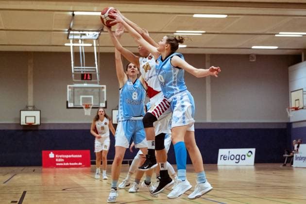 BERGISCH GLADBACH, GERMANY, DEC 2nd Anja Fuchs-Robetin ( 8 Bascats) and Carla Hermann ( 10 Bascats) steal the ball from Kimberly Pohlmann ( 14 Rheinland Lions) during the Toyota-DBBL-Cup game between the Rheinland Lions and the Capitol Bascats Düsseldorf at Schulzentrum Herkenrath, Bergisch Gladbach, Germany. T. HERZBERG Rheinland Lions vCapitol Bascats Düsseldorf 