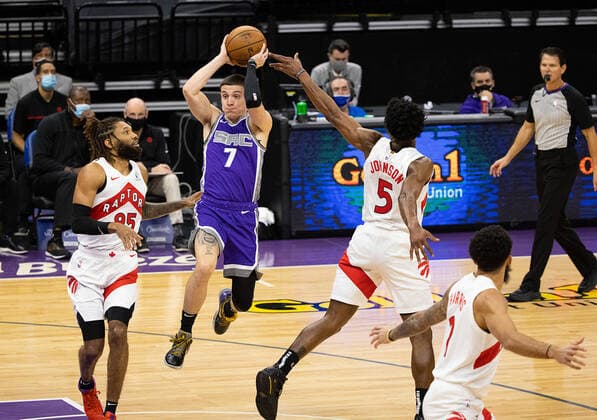 January 8, 2021, Sacramento, CA, USA: Sacramento Kings guard Kyle Guy (7) passes between Toronto Raptors forward DeAndre Bembry (95) and Toronto Raptors forward Stanley Johnson (5) during a game at the Golden 1 Center on Friday, Jan 8, 2021 in Sacramento. Sacramento USA - ZUMAj89_ 20210108_zaf_j89_021 Copyright: xPaulxKitagakixJr.x