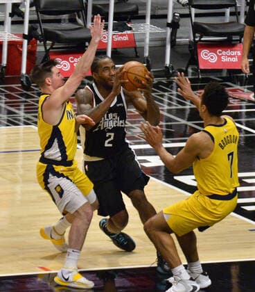 Los Angeles Clippers forward Kawhi Leonard is double teamed by Indiana Pacers point guards T.J. McConnell (L) and Malcolm Brogdon on his way to the basket during the fourth quarter at Staples Center in Los Angeles on Sunday, January 17, 2021. The Clippers defeated the short-handed Pacers 129-96.  LAP2021011710 JIMxRUYMEN