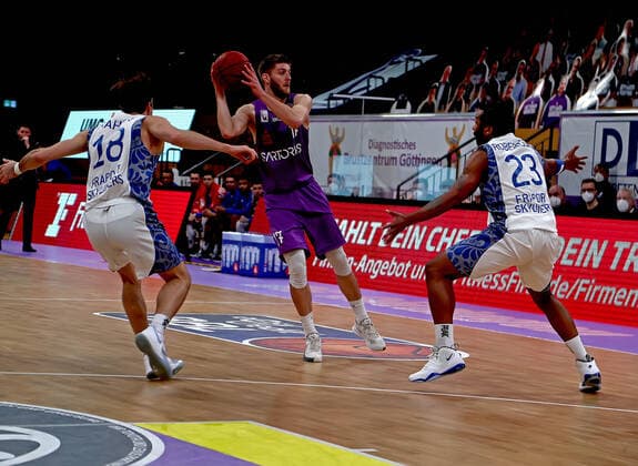 GSD zje123 Season 2020 21 Easy credit Basketball Bundesliga BG Göttingen Fraport Skyliners Göttingens Mathis Mönninghoff on the ball against Frankfurts Joe Rahon left and Quantez Robertson.
