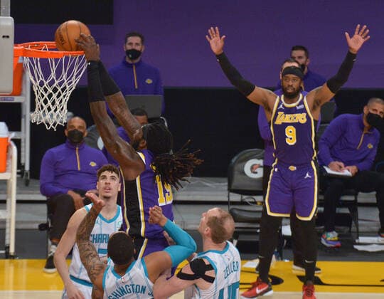 Los Angeles Lakers center Montrezl Harrell scores on Charlotte Hornets defenders during the first half at Staples Center in Los Angeles on Thursday, March 18, 2021. The Lakers defeated the Hornets 116-105.  LAP2021031810