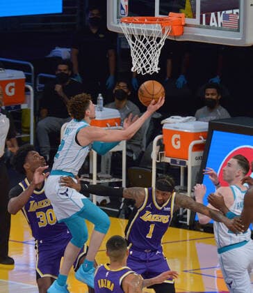 Charlotte Hornets point guard LaMelo Ball scores as he is fouled by Los Angeles Lakers guard Kentavious Caldwell-Pope during the first half at Staples Center in Los Angeles on Thursday, March 18, 2021. The Lakers defeated the Hornets 116-105.  LAP2021031813