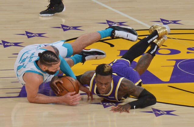 Charlotte Hornets forward Cody Martin and Los Angeles Lakers guard Dennis Schroder battle for control of the loose ball during the first half at Staples Center in Los Angeles on Thursday, March 18, 2021. The Lakers defeated the Hornets 116-105.  LAP2021031825 JIMxRUYMEN