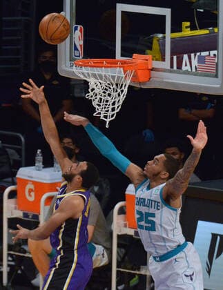 Los Angeles Lakers guard Talen Horton-Tucker scores a reverse layup on Charlotte Hornets power forward P.J. Washington during the first half at Staples Center in Los Angeles on Thursday, March 18, 2021. The Lakers defeated the Hornets 116-105.  LAP2021031819 JIMxRUYMEN