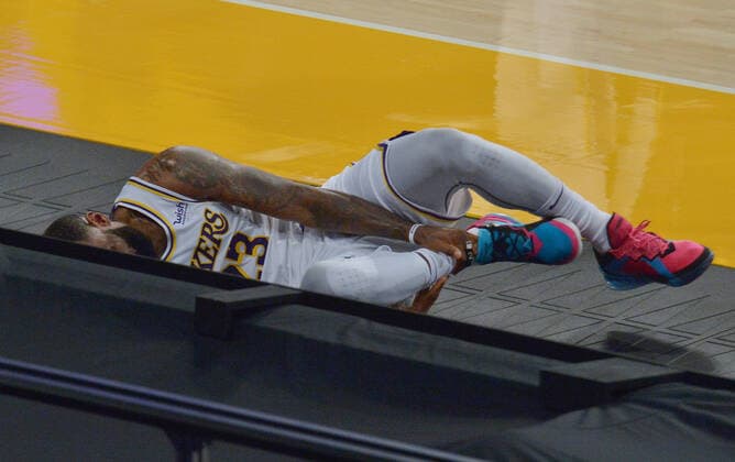 Los Angeles Lakers forward LeBron James holds his right ankle as he grimaces in pain after Atlanta Hawks forward Solomon Hill slammed his body alongside James right leg for the foul during the first half at Staples Center in Los Angeles on Saturday, March 20, 2021. James reentered the game and drilled a three-pointer before asking to be taken out because of the pain. Without James, the Lakers lost to the Hawks 99-94.  LAP2021032002 JIMxRUYMEN