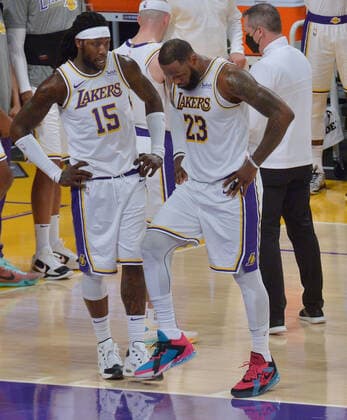Los Angeles Lakers forward LeBron James tests his right ankle after Atlanta Hawks forward Solomon Hill slammed his body alongside James right leg for the foul during the first half at Staples Center in Los Angeles on Saturday, March 20, 2021. James reentered the game and drilled a three-pointer before asking to be taken out because of the pain to his ankle. Without James, the Lakers lost to the Hawks 99-94.  LAP2021032004 JIMxRUYMEN