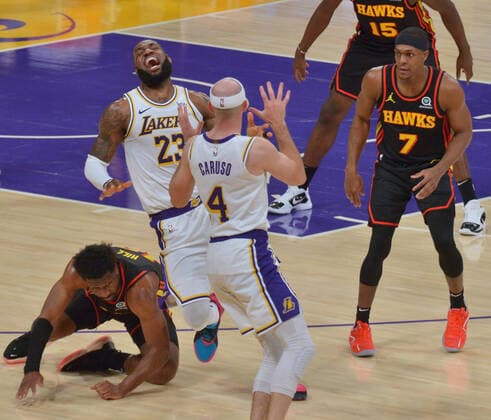 Los Angeles Lakers forward LeBron James grimaces in pain after Atlanta Hawks forward Solomon Hill slammed his body alongside James right leg for the foul during the first half at Staples Center in Los Angeles on Saturday, March 20, 2021. James reentered the game and drilled a three-pointer before asking to be taken out because of the pain. Without James, the Lakers lost to the Hawks 99-94.  LAP2021032001 JIMxRUYMEN