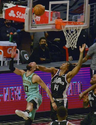 Charlotte Hornets forward Caleb Martin scores on a reverse layup over Los Angeles Clippers guard Terance Mann during the fsecond half at Staples Center in Los Angeles on Saturday, March 20, 2021. The Clippers defeated the Hornets 125-98.  LAP2021032030 LOSxANGELES