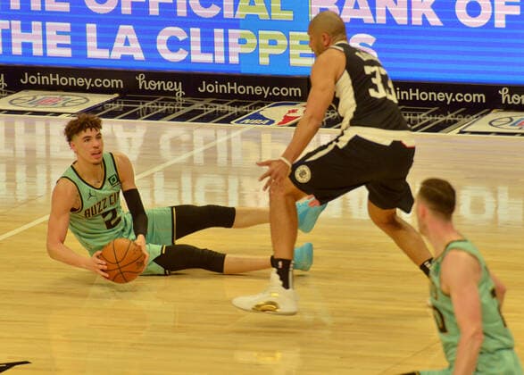 Charlotte Hornets guard LaMelo Ball looks to pass the ball from the floor under pressure from Los Angeles Clippers forward Nicolas Batum during the first half at Staples Center in Los Angeles on Saturday, March 20, 2021. The Clippers defeated the Hornets 125-98.  LAP2021032045