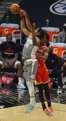 Los Angeles Clippers guard Terance Mann and Atlanta Hawks forward De Andre Hunter leap high for the offensive rebound during the first half at Staples Center in Los Angeles on Monday, March 22, 2021. The Clippers defeated the Hawks 119-110 with the comeback victory.  LAP2021032225 JIMxRUYMEN