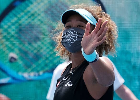 Naomi Osaka from Japan puts on a mask and celebrates after defeating Ajla Tomljanovic from Australia on the stadium court at the Miami Open at Hard Rock Stadium in Miami Gardens, Florida on Friday, March 26, 2021.  MIA20210326114 GARYxIxROTHSTEIN