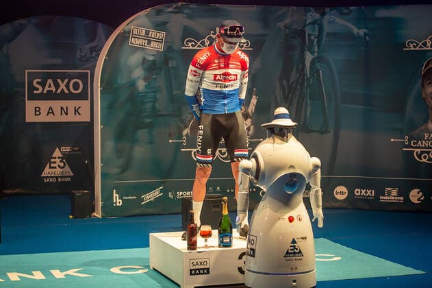 Third Mathieu van der Poel NED NL Alpecin Fenix at the award ceremony here at the winner ceremony with independent takeover of the medal from a remote controlled robot which replaces the ladies of honour podium hostesses because of the Covid 19 Corona Pandemie and the admonished contact restrictions here isolated in the sports hall of Harelbeke without spectator because of the Covid 19 Corona Pandemie Podium Award Ceremony Celebration Celebration Joy Luck Emotion Emotions Mimic Mimic Gesture Gestic Landscape landscape horizontal Event Event 64 E3 Saxo Bank Classic Harelbeke to Harelbeke 203 9 km Location Location Harelbeke Region West Vlaanderen Flanders Country Country Belgium Belgium Date Date 26 03 2021 Stiehl Photography