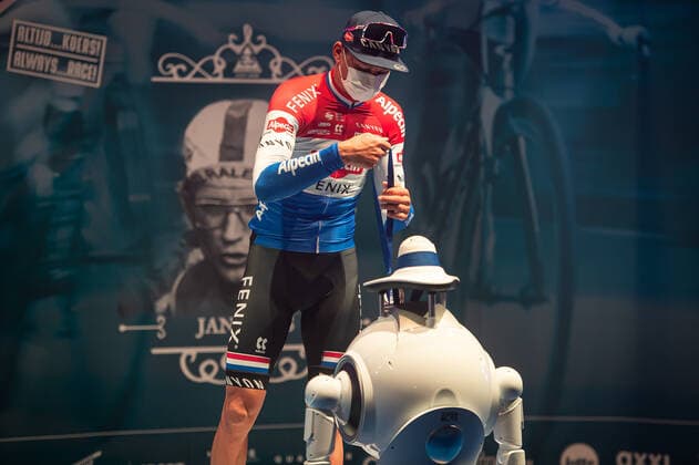 Third Mathieu van der Poel NED NL Alpecin Fenix at the award ceremony here at the winner ceremony with independent takeover of the medal from a remote controlled robot which replaces the ladies of honour podium hostesses because of the Covid 19 Corona Pandemie and the admonished contact restrictions here isolated in the sports hall of Harelbeke without spectator because of the Covid 19 Corona Pandemie Podium Award Ceremony Celebration Celebration Joy Luck Emotion Emotions Mimic Mimic Gesture Gestic Landscape landscape horizontal Event Event 64 E3 Saxo Bank Classic Harelbeke to Harelbeke 203 9 km Location Location Harelbeke Region West Vlaanderen Flanders Country Country Belgium Belgium Date Date 26 03 2021 Stiehl Photography