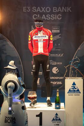 Kasper Asgreen DEN DK Deceuninck Quick Step at the award ceremony here at the winner ceremony with his own takeover of the medal from a remote controlled robot that replaces the ladies of honour podium hostesses because of the Covid 19 Corona Pandemie and the admonished contact restrictions here isolated in the sports hall of Harelbeke without spectators because of the Covid 19 Corona Pandemie Podium Award Ceremony Celebration Ceremony Joy Luck Emotion Emotion Mimic Mimic Gesture Gestic Portrait Portrait Vertical Event Event 64 E3 Saxo Bank Classic Harelbeke to Harelbeke 203 9 km Place Location Harelbeke Region West Vlaanderen Flanders Country Belgium Date 26 03 2021 Stiehl Photography
