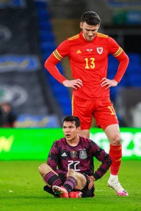 Wales v Mexico Friendly 27 03 2021. International Mexico forward Hirving Lozano (22) sits injured on the ground as Wales forward Kieffer Moore (13) looks on during the International Friendly, Länderspiel, Nationalmannschaft match between Wales and Mexico at the Cardiff City Stadium, Cardiff, Wales on 27 March 2021. Cardiff Cardiff City Stadium South Glamorgan Wales Editorial use only , Copyright: xGruffyddxThomasx PSI-12244-0062