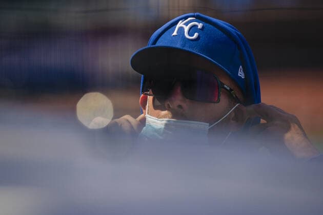 A Kansas City Royals player pokes his head out of the dugout during the game against the Texas Rangers at Kaufman Stadium in Kansas City, Missouri on Sunday, April 4, 2021.  KCP20210404207 KYLExRIVAS