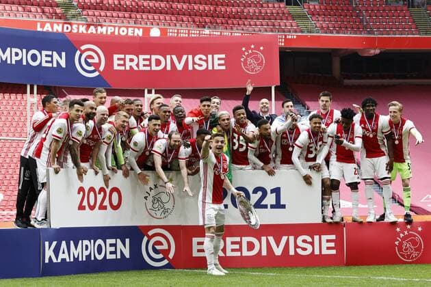 AMSTERDAM Ajax goalkeeper Maarten Stekelenburg, Jurrien Timber of Ajax, Perr Schuurs of Ajax, Edson Alvarez of Ajax, Sean Klaiber of Ajax, Davy Klaassen of Ajax, David Neres of Ajax, Ryan Gravenberch of Ajax, Oussama Idrissi of Ajax, Dusan Tadic of Ajax, Noussair Mazraoui of Ajax, Devyne Rensch or Ajax, Ajax goalkeeper Kjell Scherpen, Daley Blind or Ajax, Jurgen Ekkelenkamp or Ajax, Zakaria Labyad or Ajax, Mohammed Kudus or Ajax, Lisandro Martinez or Ajax, Sebastien Haller or Ajax, Lassina Traore or Ajax, Kenneth Taylor or Ajax, Brian Brobbey or Ajax, Nico Tagliafico or Ajax, Ajax goalkeeper Dominik Kotarski, Neraysho Kasanwirjo of Ajax, Antony Matheus Dos Santos of Ajax, Quinten Timber of Ajax, Ajax coach Erik ten Hag, Ajax assistant coach Christian Poulsen, Ajax assistant coach Michael Reiziger, Ajax assistant coach Winston Bogarde, Ajax goalkeeper coach Anton Scheutjens with the Dutch Eredivisie trophy, dish, scale during the Dutch Eredivisie match between Ajax Amst erdam and FC Emmen at the Johan Cruijff Arena on May 02, 2021 in Amsterdam, The Netherlands ANP MAURICE VAN STEEN Dutch Eredivisie 2020 2021 xVIxANPxSportx xxANPxIVx 430947942