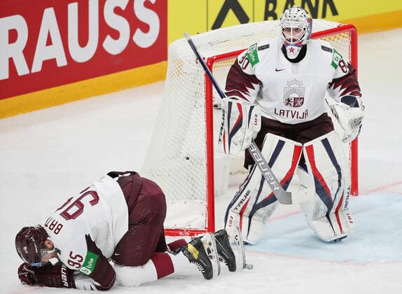 Eishockey, WM, Kanada - Lettland RIGA, LATVIA - MAY 21, 2021: Latvia s injured Oskars Batna (L) and goaltender Matiss Kivlenieks in their 2021 IIHF World Championship, WM, Weltmeisterschaft Group A Ice hockey, Eishockey match at Arena Riga. Natalia Fedosenko TASS  TS100E47