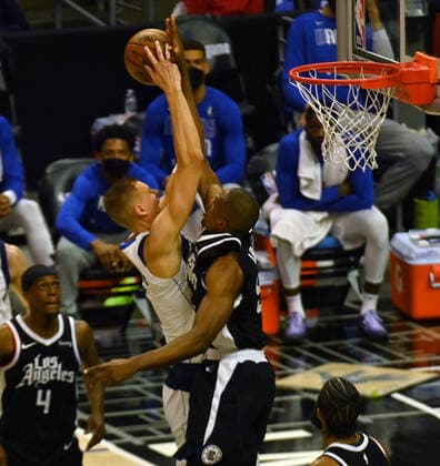 Los Angeles Clippers center Serge Ibaka (9) fouls Dallas Mavericks center Kristaps Porzingis (6) during the first half of their best-of-seven playoff series opener at Staples Center in Los Angeles on Saturday, May 22, 2021. The Mavericks defeated the Clippers 113-103.  LAP2021052211 JIMxRUYMEN
