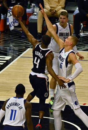 Los Angeles Clippers guard Rajon Rondo (13) scores on a layup over Dallas Mavericks center Kristaps Porzingis (6) during the first half of their best-of-seven playoff series opener at Staples Center in Los Angeles on Saturday, May 22, 2021. The Mavericks defeated the Clippers 113-103.  LAP2021052219 JIMxRUYMEN