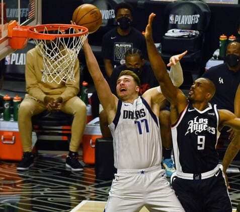 Dallas Maverick s guard Luka Doncic (77) scores as he is fouled by Los Angeles Clippers center Serge Ibaka (9) during the second half of their best-of-seven playoff series opener at Staples Center in Los Angeles on Saturday, May 22, 2021. The Mavericks defeated the Clippers 113-103.  LAP2021052223 JIMxRUYMEN