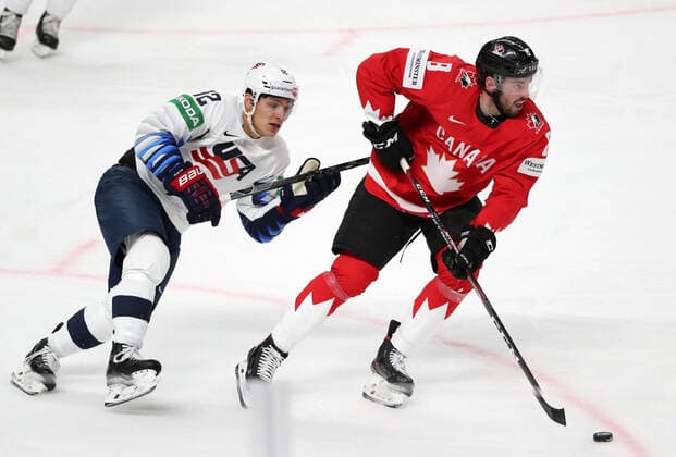 RIGA, LATVIA - MAY 23, 2021: The USA s Trevor Moore (L) and Canada s Liam Foudy fight for the puck in their 2021 IIHF World Championship, WM, Weltmeisterschaft Group B Ice hockey, Eishockey match at Arena Riga. Natalia Fedosenko TASS  TS10114B