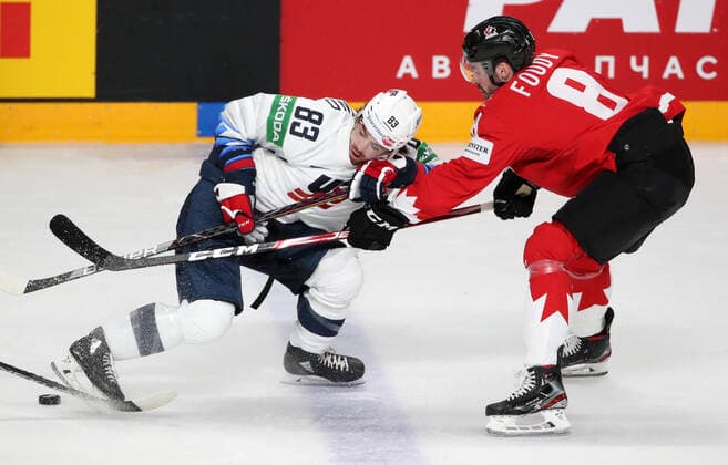 RIGA, LATVIA - MAY 23, 2021: The USA s Conor Garland (L) and Canada s Liam Foudy fight for the puck in their 2021 IIHF World Championship, WM, Weltmeisterschaft Group B Ice hockey, Eishockey match at Arena Riga. Natalia Fedosenko TASS  TS10118A