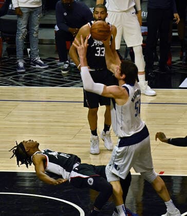 Los Angeles Clippers guard Terance Mann (14) falls backwards on the offensive foul by Dallas Mavericks center Boban Marjanovic (51) during the fourth quarter in Game 5 of their best-of-seven playoff series at Staples Center in Los Angeles on Wednesday, June 2, 2021. The Clippers lost to Dallas 105-100, their championship ambitions are hanging on for dear life trailing 3-2 in the series, with Game 6 coming on Friday in Dallas.  LAP2021060217 JIMxRUYMEN
