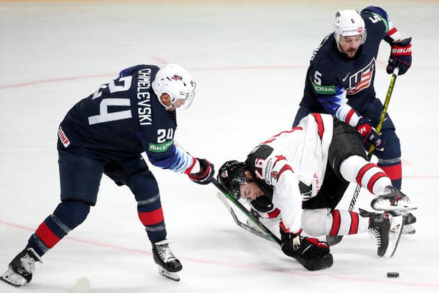 RIGA, LATVIA - JUNE 5, 2021: Alexander Chmelevski of the USA, Sean Walker of Canada and Adam Clendening (L-R) of the USA fight for the puck in their 2021 IIHF World Championship, WM, Weltmeisterschaft semifinal match at Arena Riga. Natalia Fedosenko TASS  TS103BBE