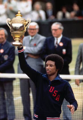 Tennis - 1975 Wimbledon Championships Mens Final Arthur Ashe v Jimmy Connors Arthur Ashe - United States of America lifts the Mens trophy on Centre court Ashe had deliberately walked onto court wearing his Davis Cup tracksuit top to highlight his disgust at Connors attitude to not playing for his country. 