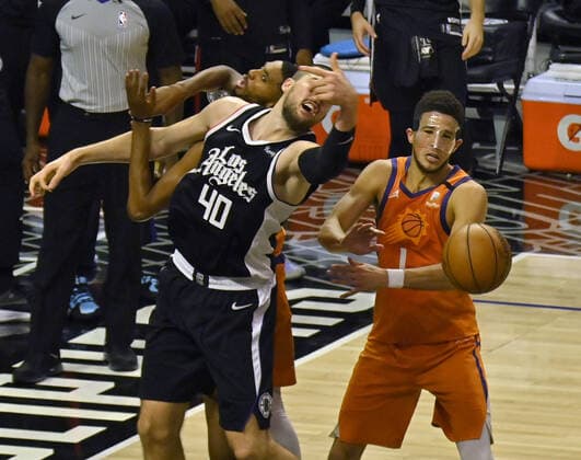 Los Angeles Clippers center Ivica Zubac (40) loses control of the ball under pressure from Phoenix Suns guard Devin Booker (1) during the fourth quarter in Game 3 of their best-of-seven Western Conference finals matchup at Staples Center in Los Angeles on Thursday, June 24, 2021. After dropping the opening two games in Phoenix, the Clippers took Game 3, 106-92 by staying in control throughout.  LAP2021062404 JIMxRUYMEN