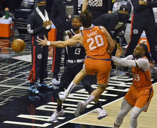 Los Angeles Clippers forward Paul George (13) makes the pass to the corner past Phoenix Suns center Dario Saric (20) during the fourth quarter in Game 3 of their best-of-seven Western Conference finals matchup at Staples Center in Los Angeles on Thursday, June 24, 2021. After dropping the opening two games in Phoenix, the Clippers took Game 3, 106-92 by staying in control throughout.  LAP2021062417 JIMxRUYMEN