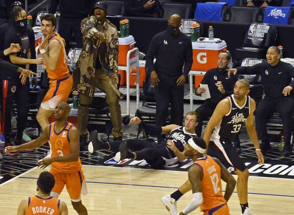 Los Angeles Clippers guard Luke Kennard (5) falls to the floor on the foul by Phoenix Suns center Dario Saric (20) and scoring a three-pointer for the four-point play during the fourth quarter in Game 3 of their best-of-seven Western Conference finals matchup at Staples Center in Los Angeles on Thursday, June 24, 2021. After dropping the opening two games in Phoenix, the Clippers took Game 3, 106-92 by staying in control throughout.  LAP2021062418 JIMxRUYMEN