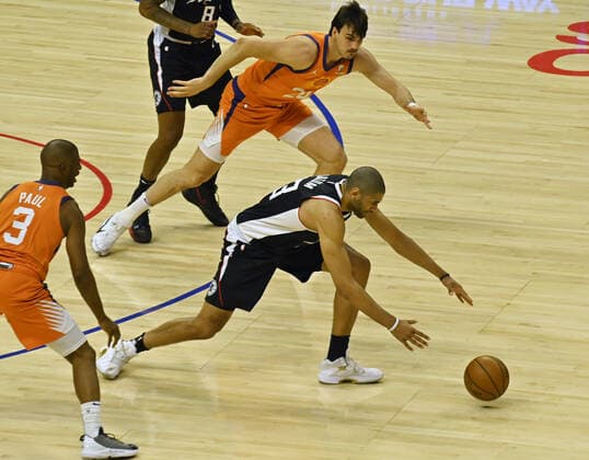 Los Angeles Clippers forward Nicolas Batum (33) chases the loose ball after stealing it from Phoenix Suns center Dario Saric (20) during the first half in Game 3 of their best-of-seven Western Conference finals matchup at Staples Center in Los Angeles on Thursday, June 24, 2021. After dropping the opening two games in Phoenix, the Clippers took Game 3, 106-92 by staying in control throughout.  LAP2021062427 JIMxRUYMEN