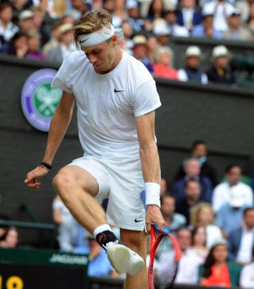 Lawn Tennis - 2021 All England Championships - Week Two - Friday - Wimbledon Mens Semi Final - Novak Djokovic v Denis Shapovalov Denis Shapovalov bags his racket with his foot after a missed chance 