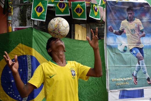 India: Brazil Football supporter support their team ahead of Copa America final in Kolkata A Supporter of Brazil wearing Brazil football jersey juggling with a football next to a Brazil national flag ahead of Copa America Football final match between Brazil and Argentina in Kolkata. Kolkata West Bengal India Copyright: SudiptaxDas