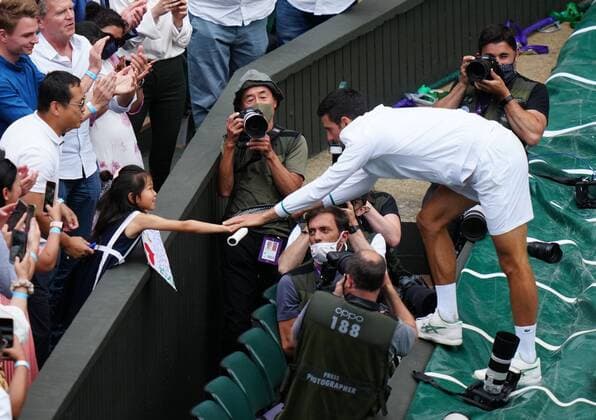 Mandatory Credit: Photo by Shutterstock (12204579dv) Novak Djokovic hands his racquet to a young fan after victory in the Gentlemen s Singles final Wimbledon Tennis Championships, Day 13, The All England Lawn Tennis and Croquet Club, London, UK - 11 Jul 2021 Wimbledon Tennis Championships, Day 13, The All England Lawn Tennis and Croquet Club, London, UK - 11 Jul 2021  Copyright: xShutterstockx 12204579dv