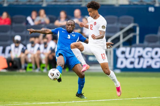 KANSAS CITY, KS - JULY 11: Canada forward Tajon Buchanan (12) pushes past the outstretched leg of Martinique midfielder Karl Vitulin (5) during the CONCACAF Gold Cup match between Canada and Martinique on Sunday, July 11, 2021 at Children™s Mercy park in Kansas City, KS. (Photo by Nick Tre. Smith Icon Sportswire) SOCCER: JUL 11 Concacaf Gold Cup - Canada v Martinique Icon2107110050