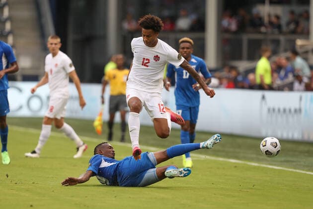 KANSAS CITY, KS - Jul 11: Canada forward Tajon Buchanan (12) leaps over a Martinique defender in the second half of a Concacaf Gold Cup match between Canada and Martinique on Jul 11, 2021 at Children s Mercy Park in Kansas City, KS. (Photo by Scott Winters Icon Sportswire) SOCCER: JUL 11 Concacaf Gold Cup - Canada v Martinique Icon2107110190